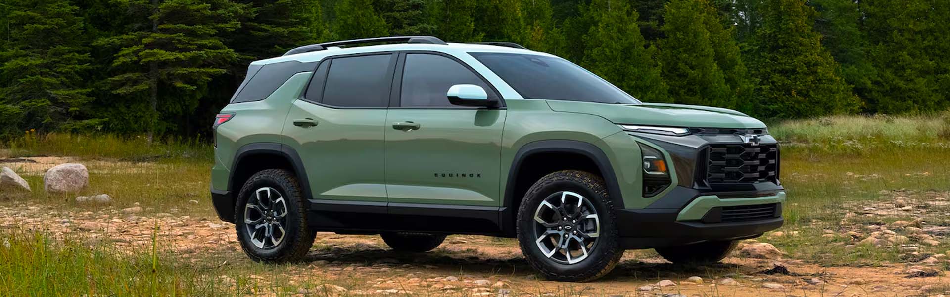 2026 Chevrolet Equinox AWD compact SUV in green, featuring updated front fascia, LED headlights, black accents, and sporty wheels in outdoor landscape