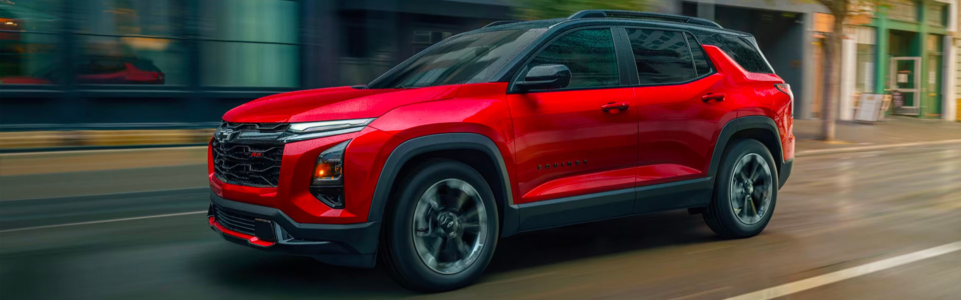 A red 2026 Chevrolet Equinox SUV moving on a street, showing its sleek design and modern features.