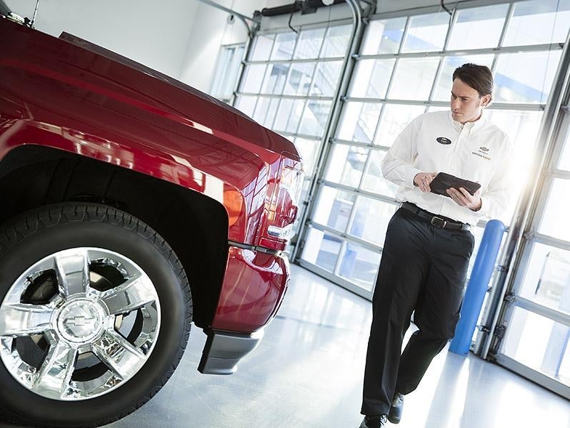 Dealership employee inspecting vehicle